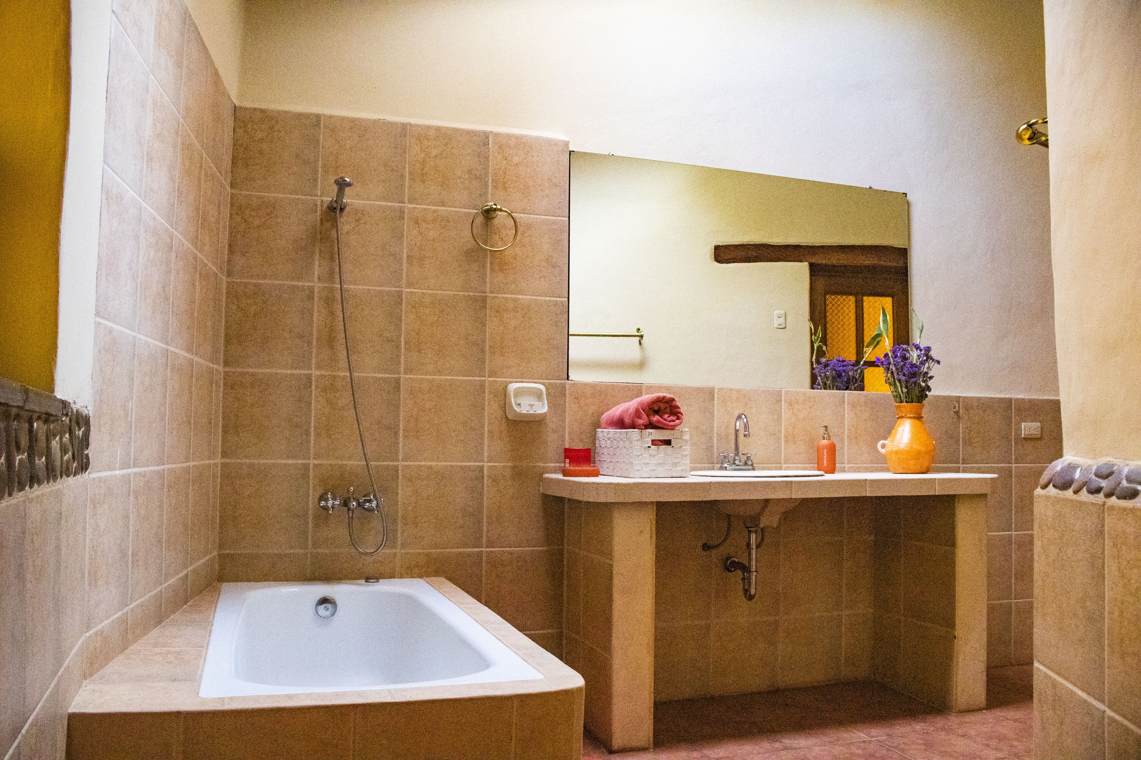 A bathroom with a bathtub, a sink, and a mirror.