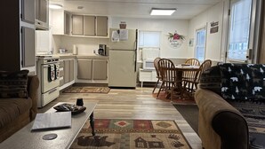 A compact kitchen with a dining area, a sofa, and a coffee table.