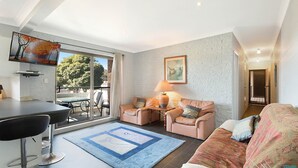 Ein modernes Wohnzimmer mit einer Couch, einem Couchtisch und einem Essbereich mit Tisch und Stühlen.