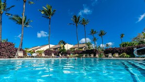 A clear blue pool with lounge chairs and palm trees. - Maui Kamaole #A-210 Panoramic Ocean View, Full A/C, Across Kamaole Bch III (Kihei)