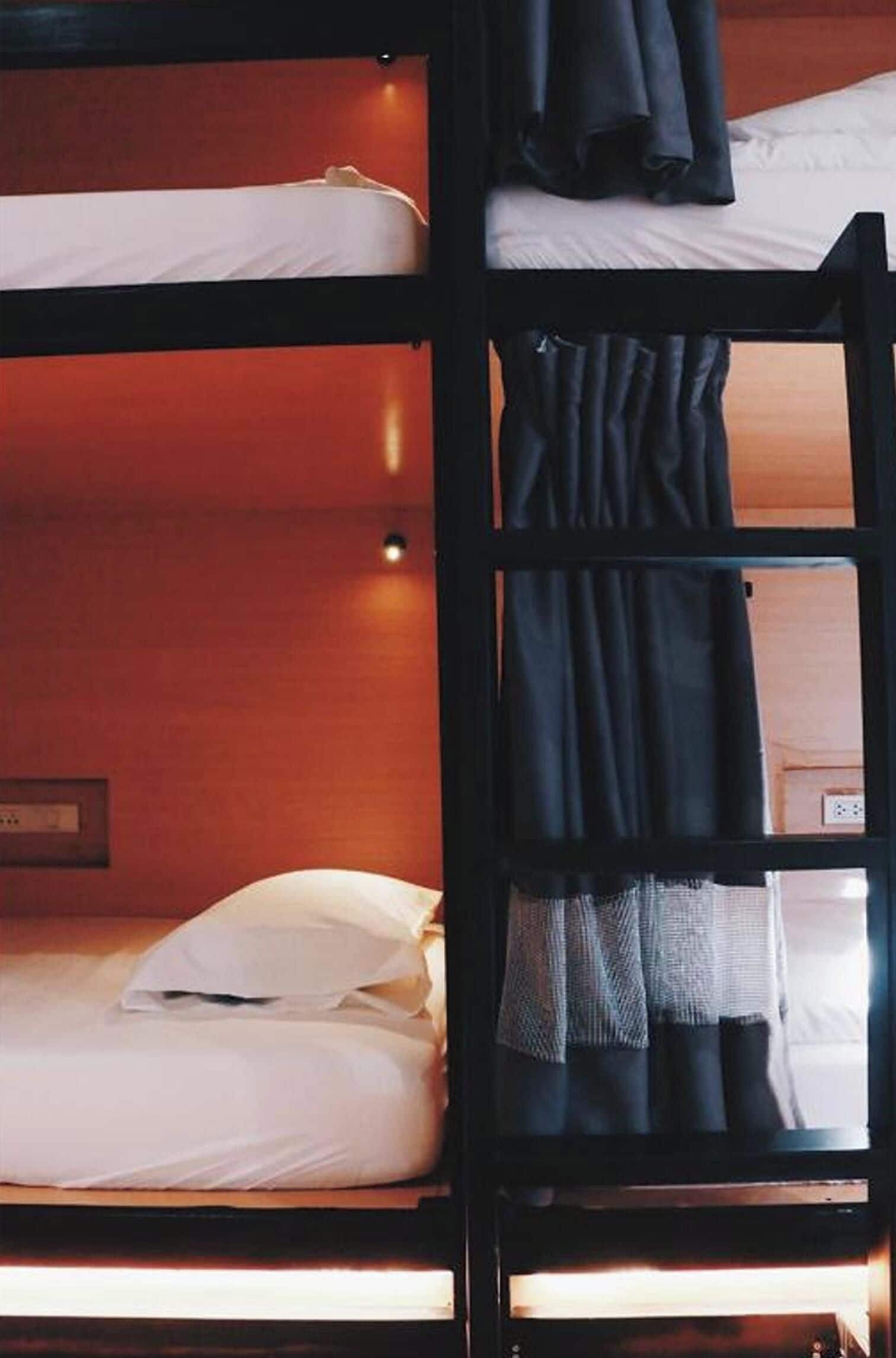 A bunk bed with white bedding and a wooden headboard.