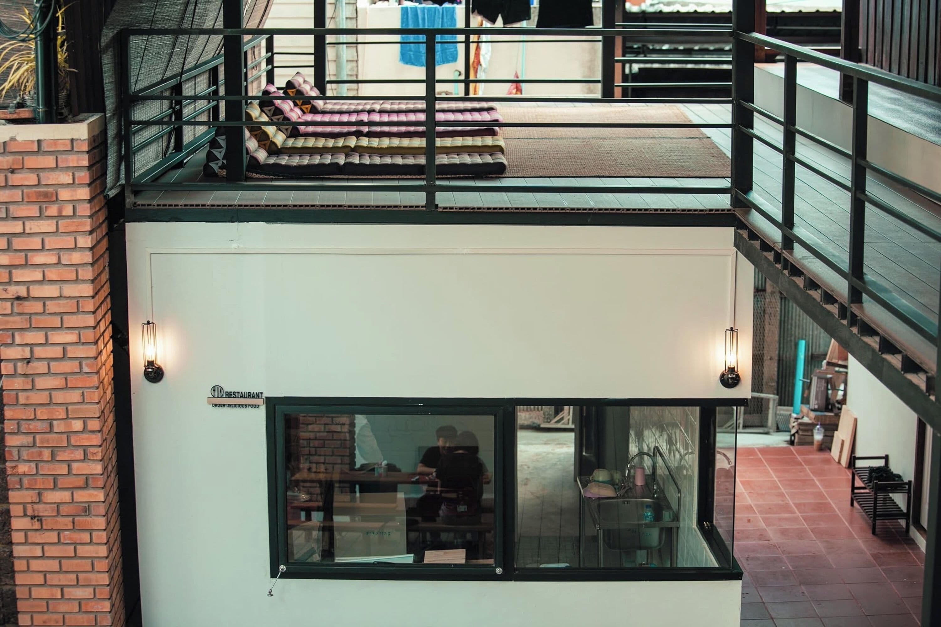 Un bâtiment à deux étages doté d’un balcon, d’un coin repas et d’une cuisine ouverte.