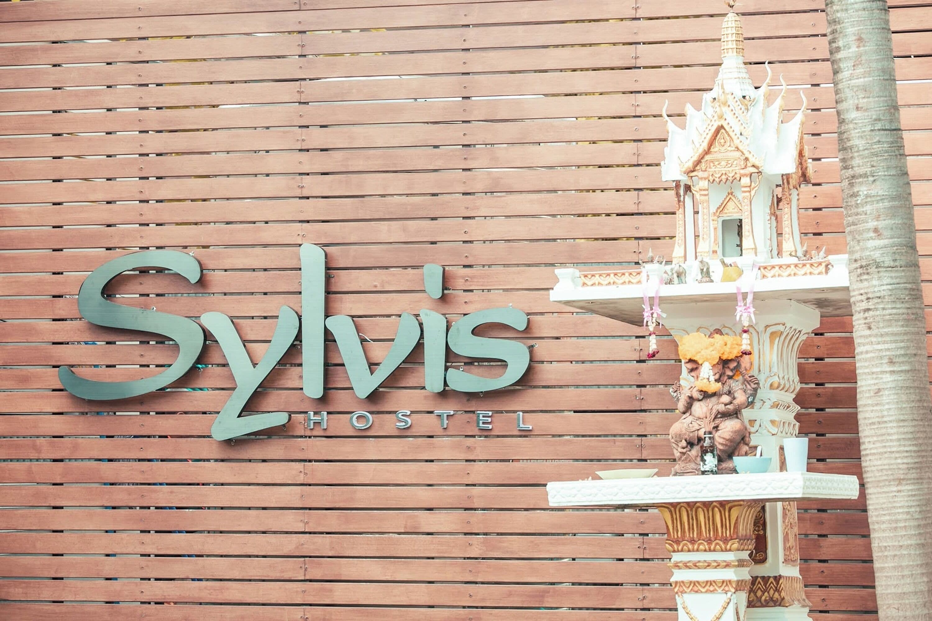 A hostel sign with a traditional architectural model.