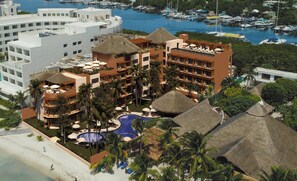 A resort with multiple buildings, a swimming pool, and a marina with boats.