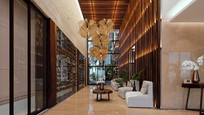 A modern lobby with a glass wall, wooden ceiling, and a central seating area. - Belo Isla Mujeres All Inclusive (Isla Mujeres)
