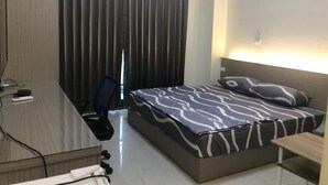 Una habitación de hotel con una cama, un escritorio y una silla.