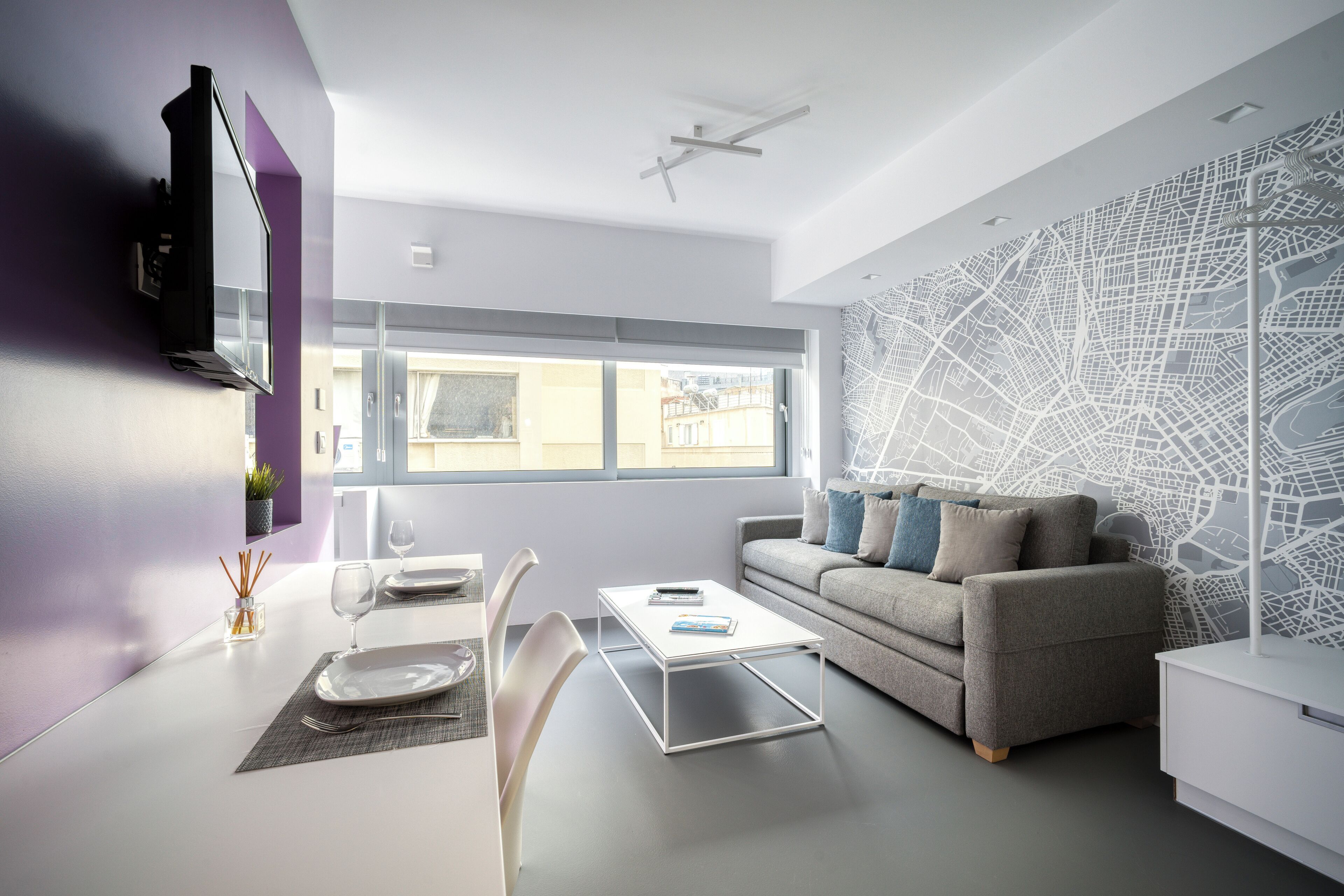 Een moderne woonkamer met een bank, salontafel en eettafel.