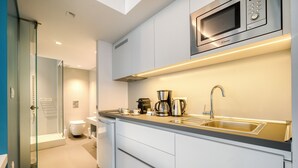 A modern kitchen with a built-in microwave, coffee maker, and sink. - Athens Color Cube (Athens)