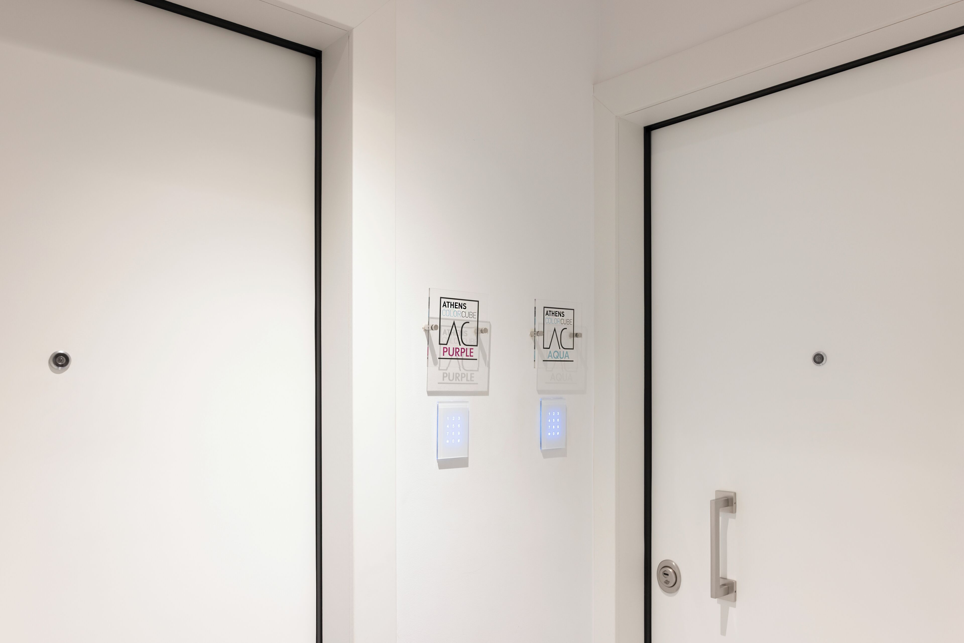 Two doors with signs indicating room types: 'Athens Purple' and 'Athens Aqua'.