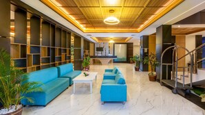 A spacious lobby with a blue sofa set, a white coffee table, and a marble floor. - Best Western Setiabudhi Bandung (Bandung)