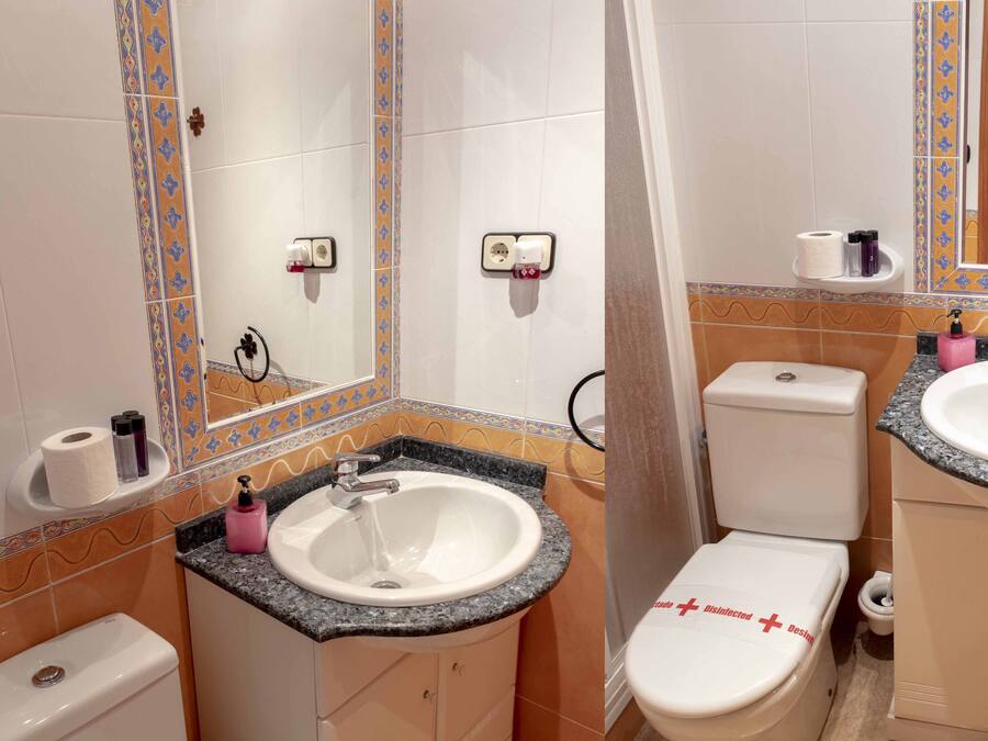 A bathroom with a white sink, a toilet, and a shower area.