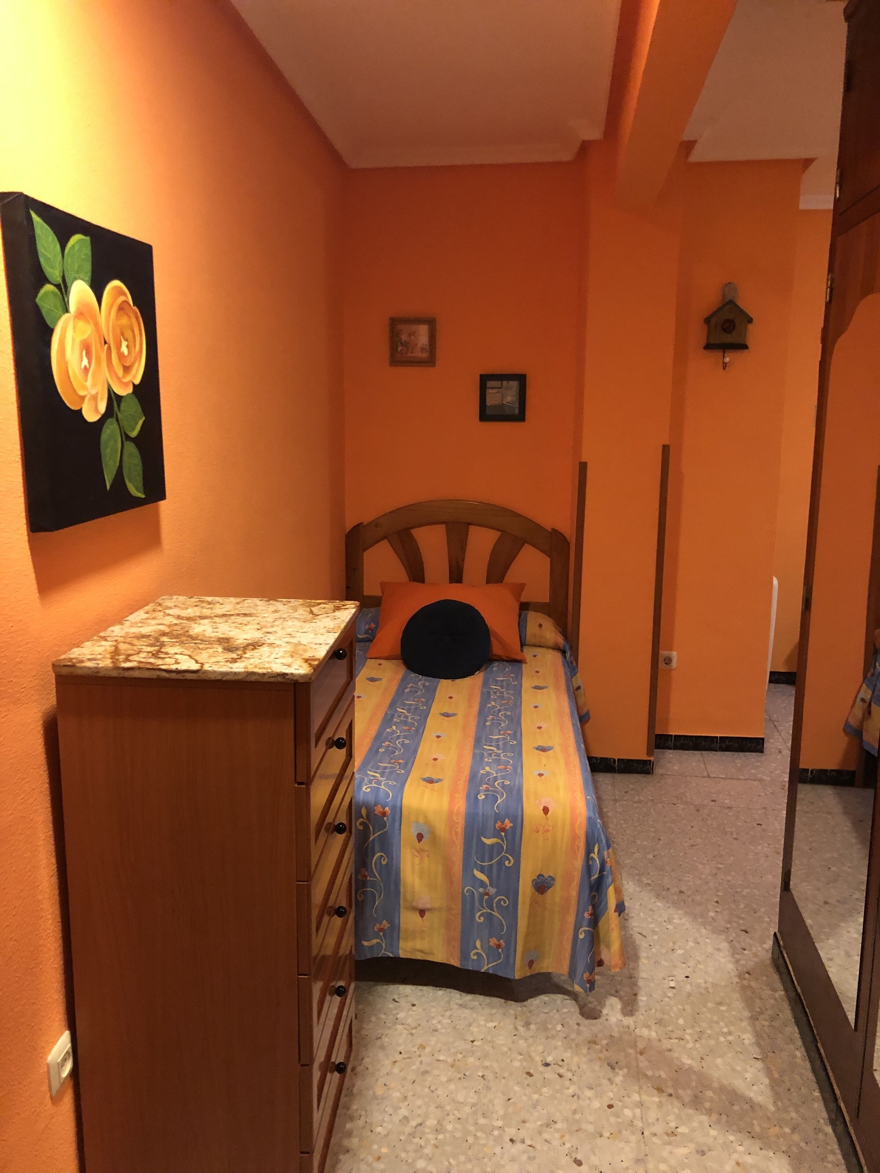 Un dormitorio con cama, cómoda y un cuadro en la pared.