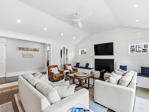 A modern living room with a fireplace, sofas, and a television.