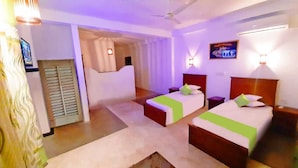 A hotel room with two beds, a television, and a ceiling fan. - Akurala Beach Boutique Resort (Akurala)