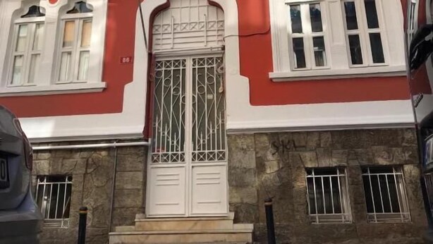 A building with a red and white facade, a central entrance with a decorative door, and the initials "MCM" above the door. - Kalkedon Hostel (Istanbul)