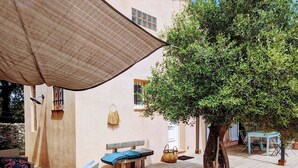 A patio area with wicker furniture, a bench, and a tree. - Villa Bonifacio 12p, swimming pool -1km from the port Preserved and exceptional environment (Bonifacio)