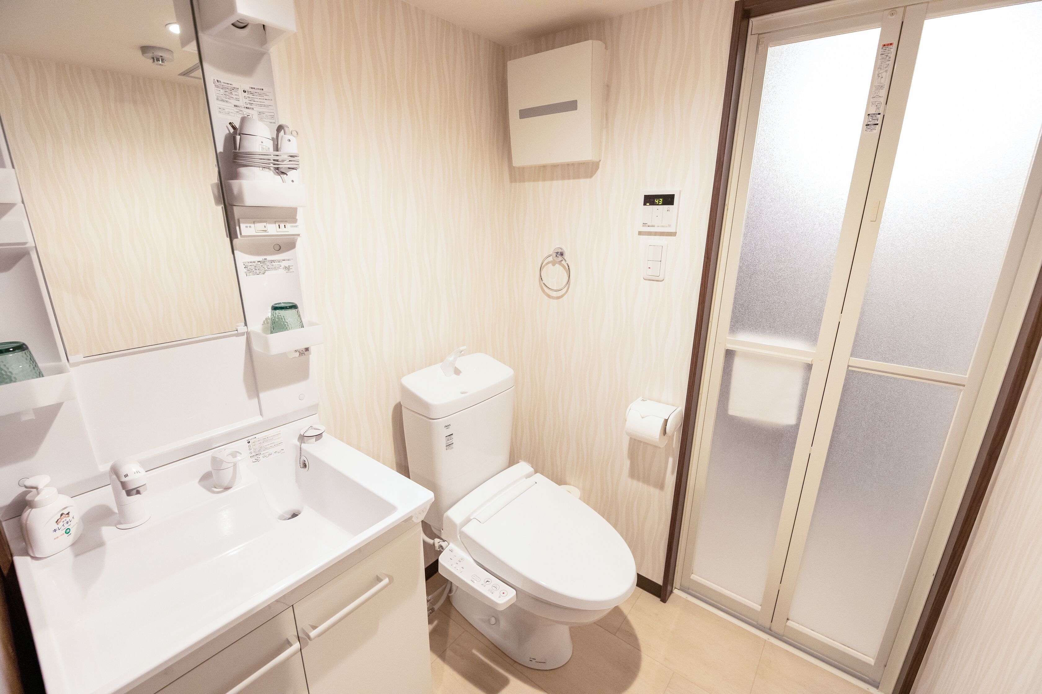 Une salle de bain moderne équipée de toilettes, d’un lavabo et d’une douche à parois en verre.