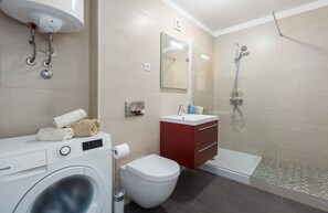 Regadera, secadora de cabello, toallas, papel de baño 