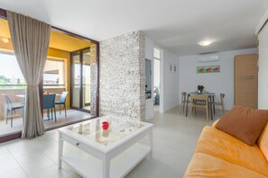A modern living room with a glass coffee table, a sofa, and a dining area with a table and chairs. - Right in the Porec center, near the beach,WiFi,air conditioning,garage, elevator (Porec)