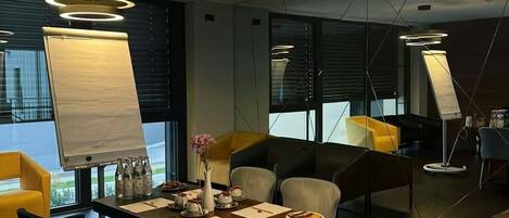 A modern conference room with a large table, chairs, and a whiteboard.
