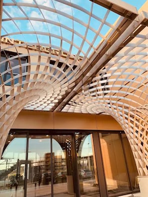 A modern building with a distinctive curved glass facade and a metal framework.