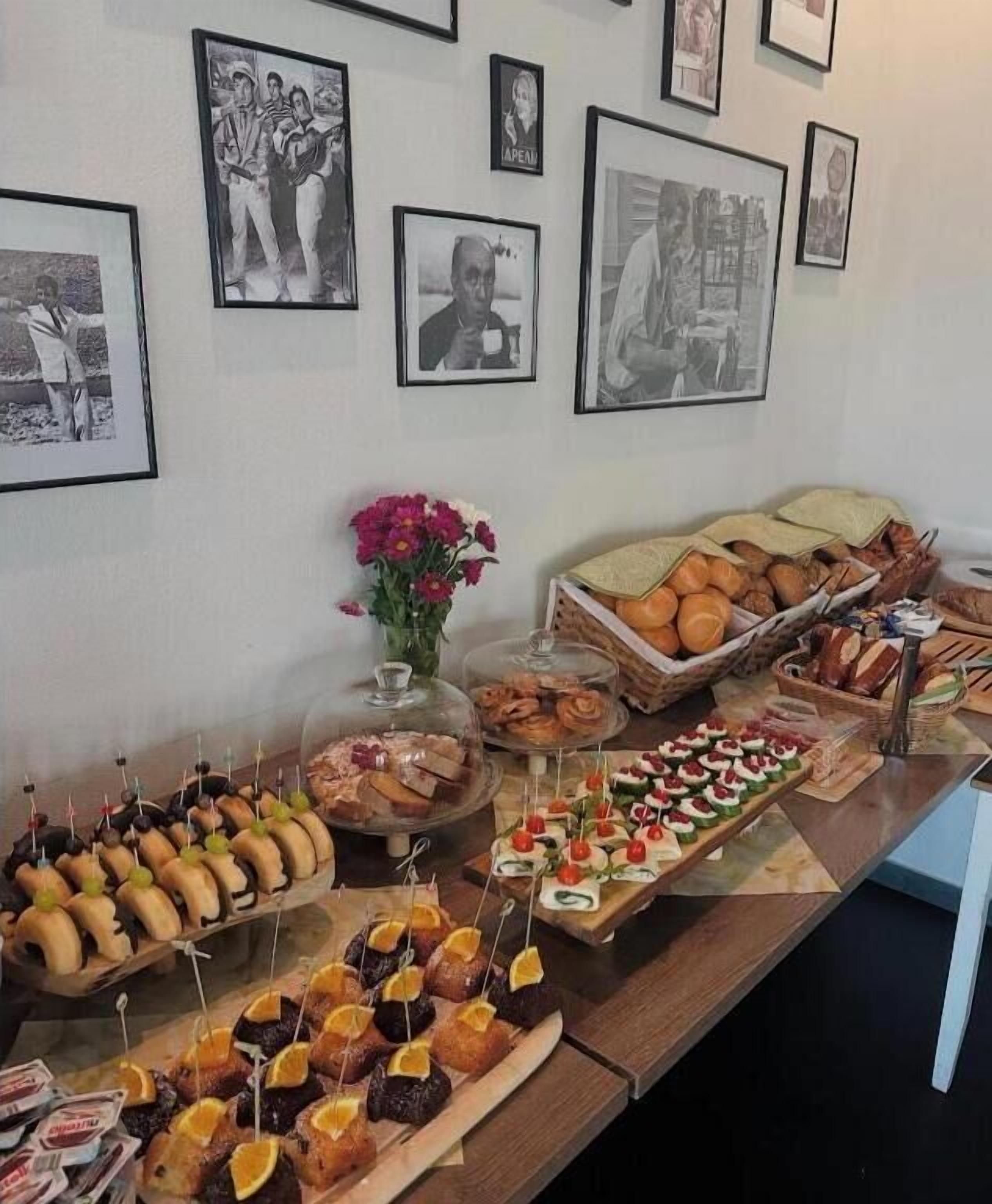 Un bufé con diversos alimentos y una pared decorada con cuadros.