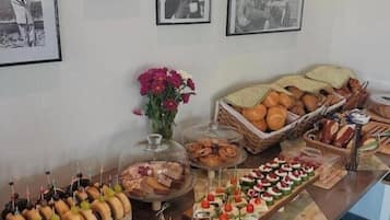 Un bufé con diversos alimentos y una pared decorada con cuadros.