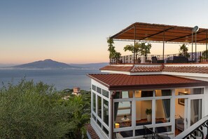 A modern building with a balcony overlooking a coastal view. - AMORE RENTALS - Villa Bianca with Private Swimming Pool, Sea View, Terraces, Parking and Barbecue (Sorrento)
