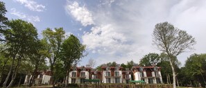A row of multi-story residential buildings with balconies, surrounded by trees and a clear sky. - Yıldız Country Hotel (Sinop)