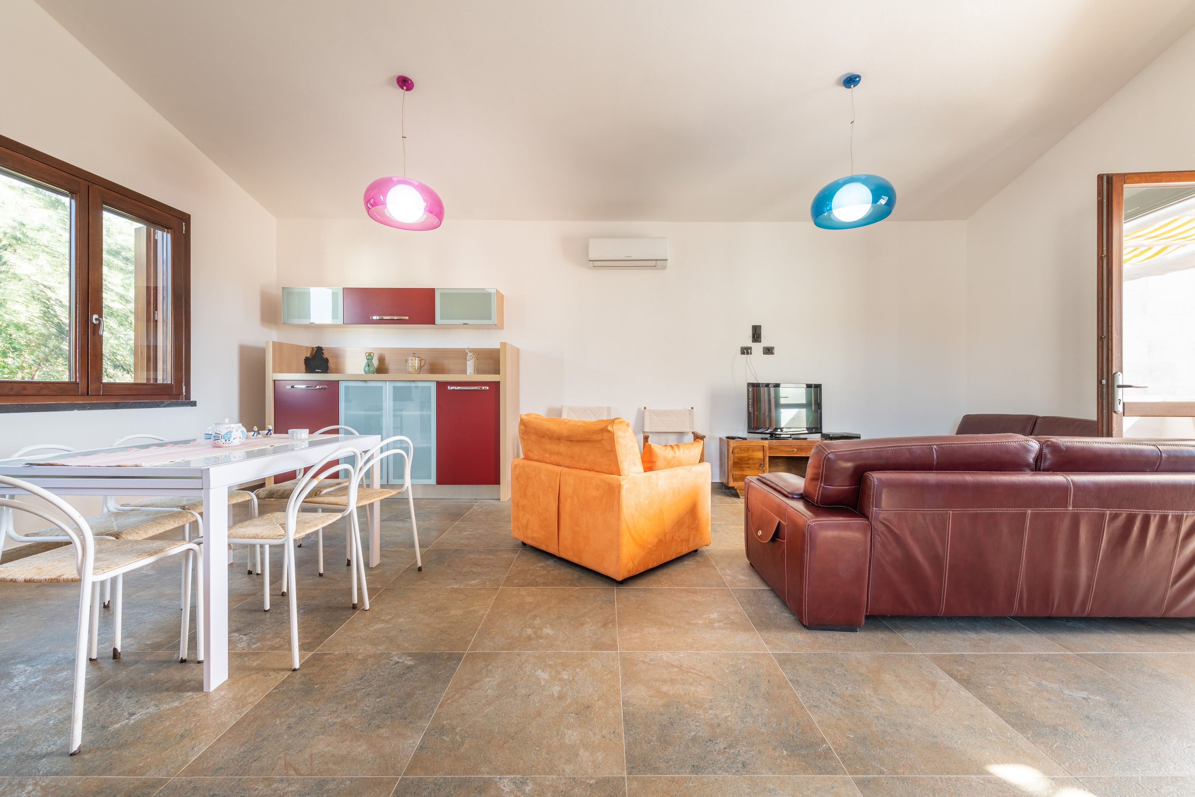 Un salon moderne comprenant un coin repas, un canapé et un téléviseur.