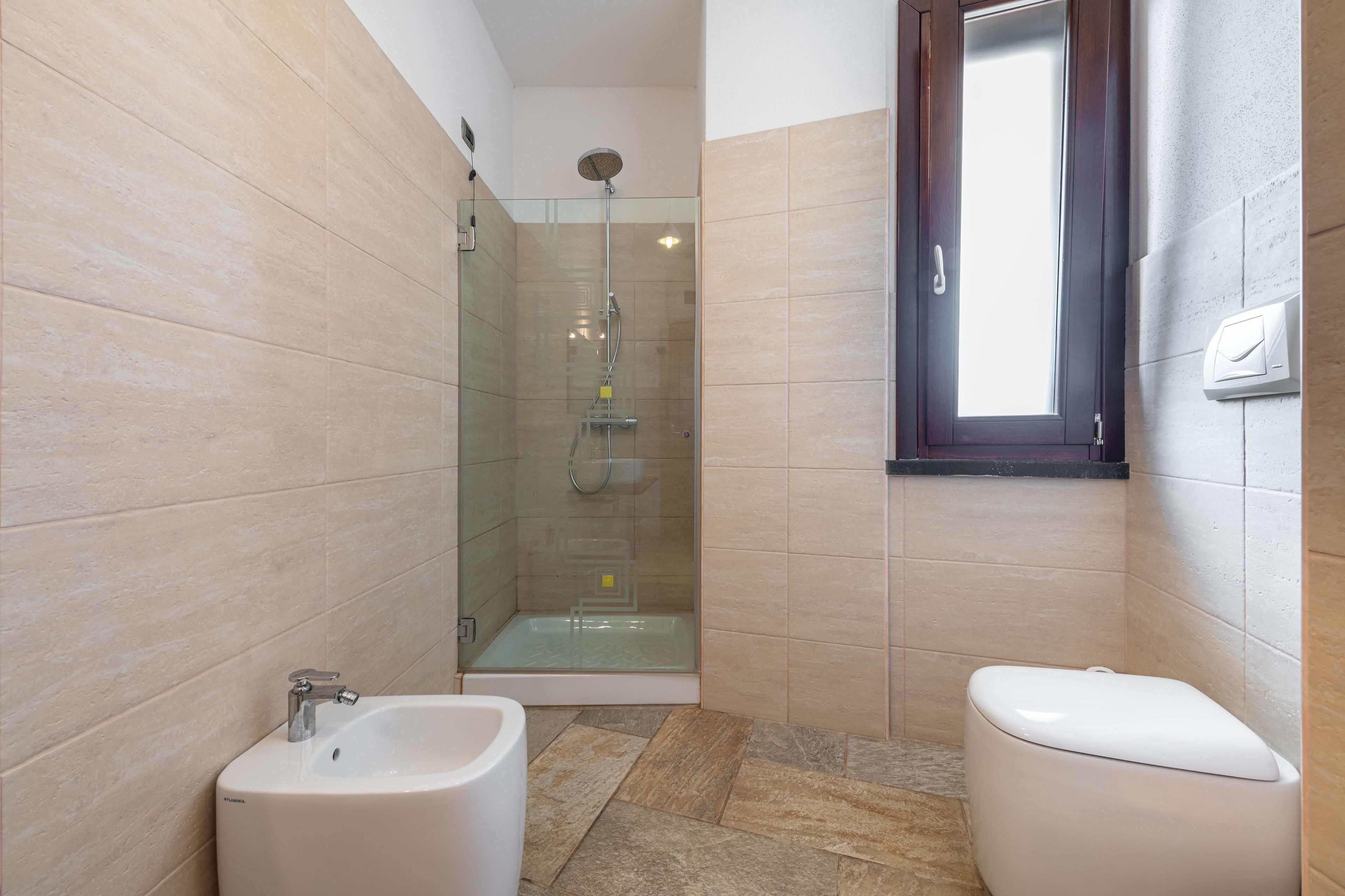 Ein modernes Badezimmer mit einer Duschkabine, einem Waschbecken und einer Toilette.