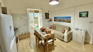 A compact living space with a dining area, kitchenette, and a sofa. - CasaBattista10 Comfort and Relax (Matera)