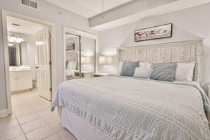 Un dormitorio con una cama grande, un cabecero de madera y una mesita de noche con lámparas.