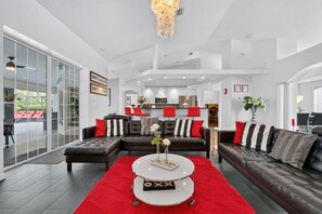A modern living room with a sectional sofa, a coffee table, and a red rug. - Stunning Executive Ruyper 4 Bedroom Home by RedAwning (Inverness)
