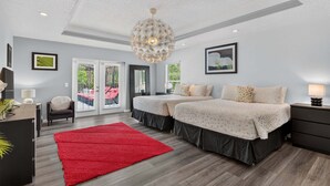 A modern bedroom with two beds, a red rug, and a chandelier. - Stunning Executive Ruyper 4 Bedroom Home by RedAwning (Inverness)