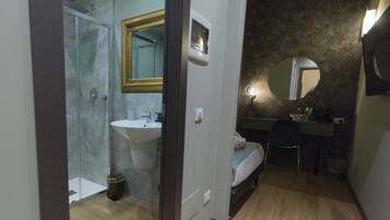 Habitación de hotel con ducha, lavabo y cama.