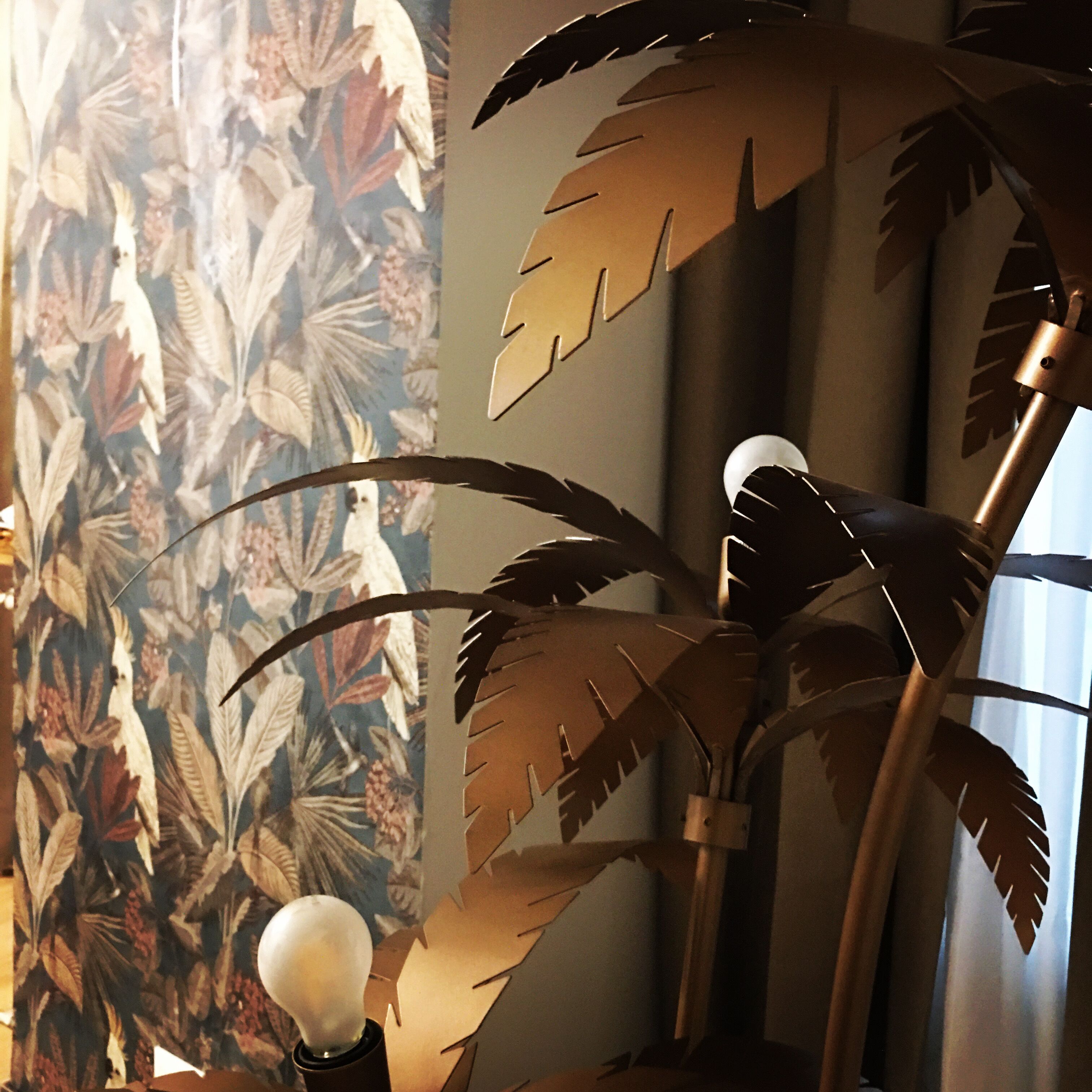 A decorative metal plant with leaves and a light bulb.