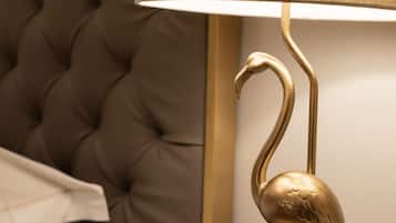 Ein gebürstetes Kopfbrett und eine goldfarbene, schwanförmige Lampe.
