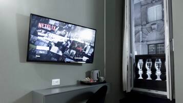 Een flatscreen-tv aan een muur, waarop een Netflix-interface wordt weergegeven.