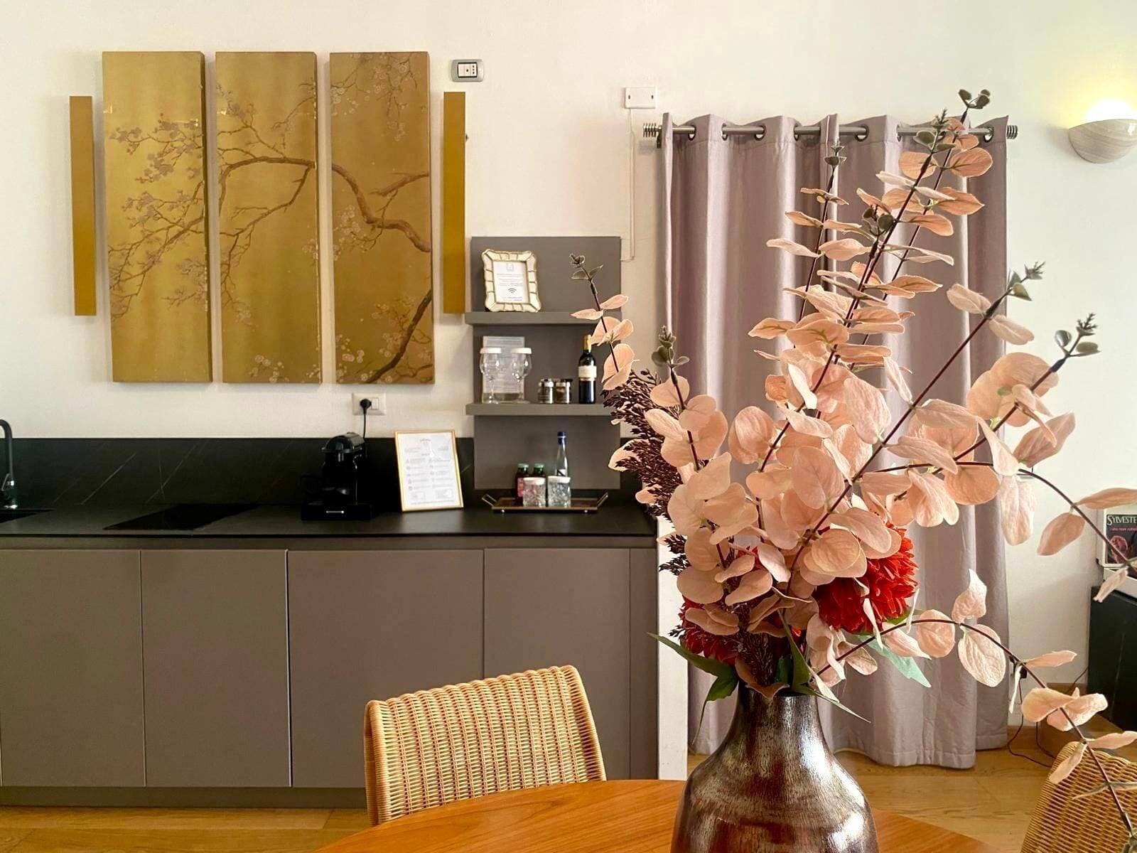 A modern kitchen with a dark countertop, a coffee machine, and a framed menu on the wall.