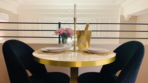 A round table with a gold base, white plates, and a gold candle holder. - INTOMILAN  Galleria Duomo - Boutique & Design Aparthotel (Milan)