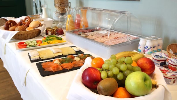 A buffet table with various food items including fruits, cheeses, meats, and pastries. - Hubertushöhe (Regensburg)