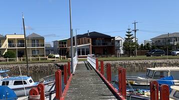 A wooden pier leading to a marina with boats docked on both sides.