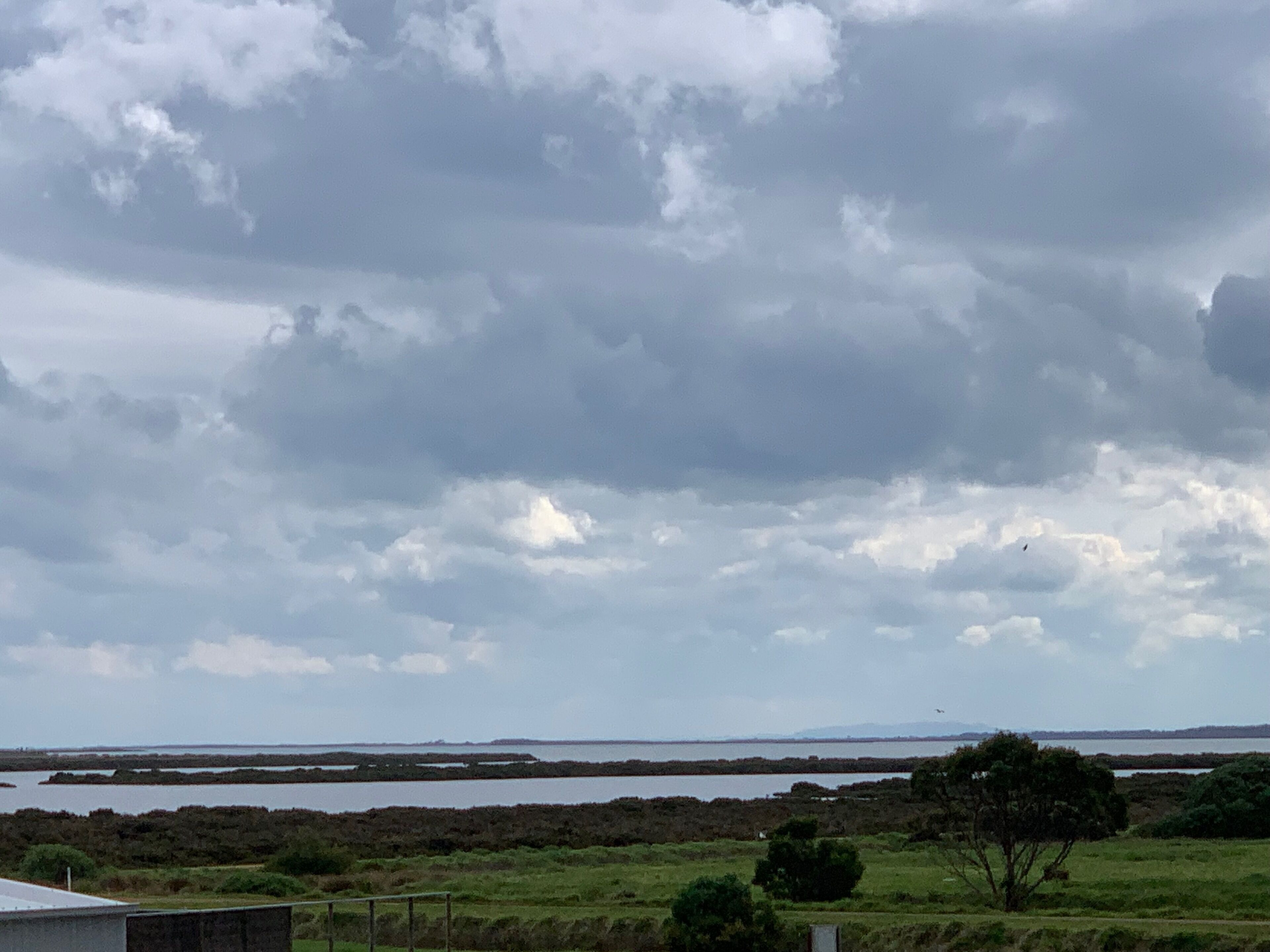 A coastal landscape with a view of the sea and a cloudy sky.