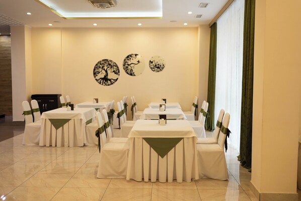 A banquet hall with tables set for events, featuring a modern design with a neutral color palette.