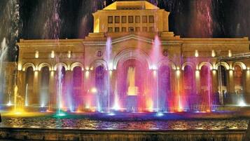 A building with a central archway and multiple fountains.