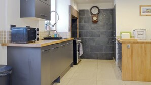 Una cucina moderna con forno integrato, lavello e orologio a parete.