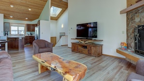 A spacious living room with a wooden ceiling, a stone fireplace, a large flat-screen TV, and a wooden coffee table. - 15 Big Leaf - Remodeled, Grassy Lawn, Fabulous Location, SHARC Passes, A/C (Bend)