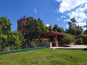 A building with a red roof and a covered patio area. - Hostal Yanelis & Harol (Trinidad)