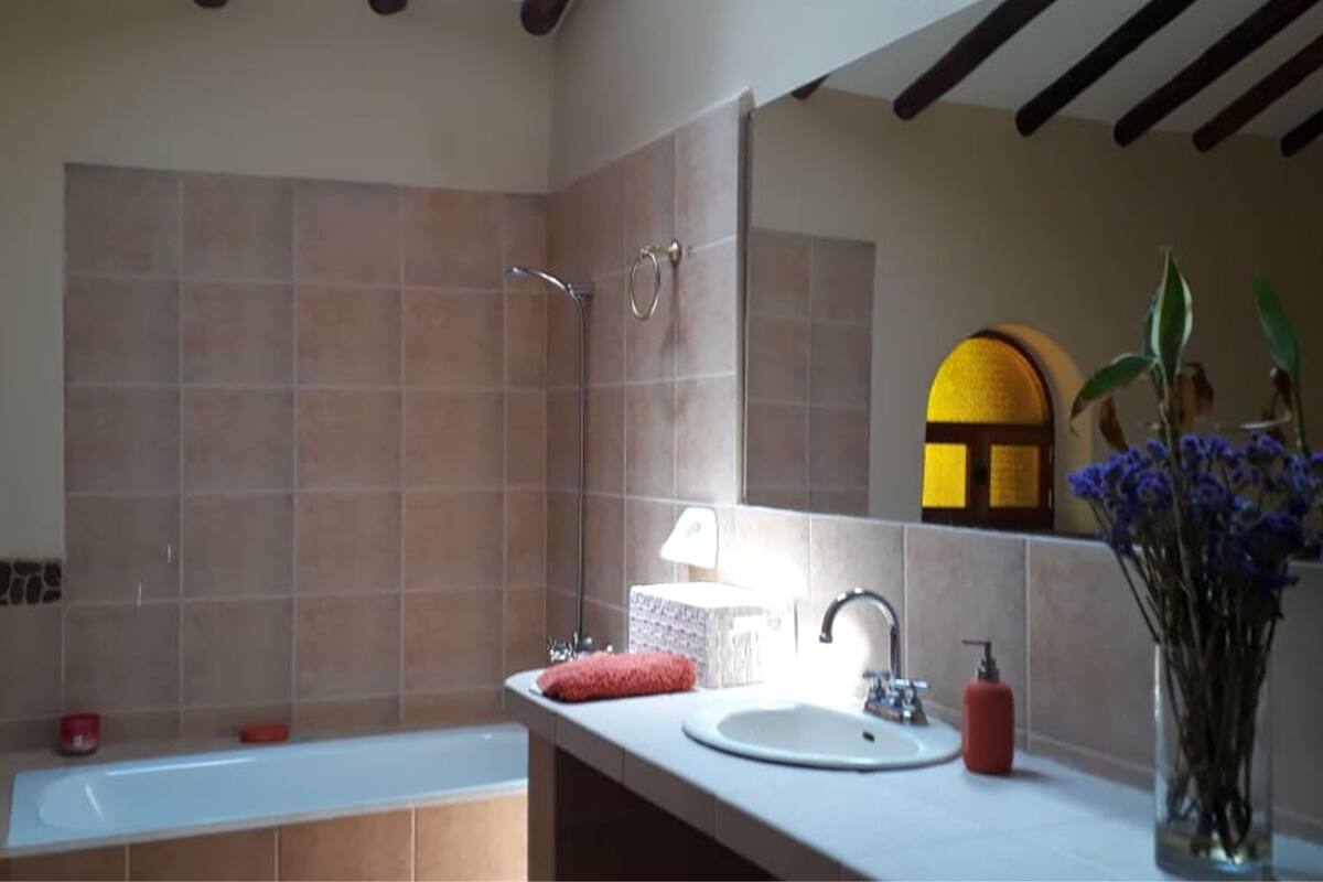 Ein Badezimmer mit Badewanne, Waschbecken, Spiegel und Fenster.